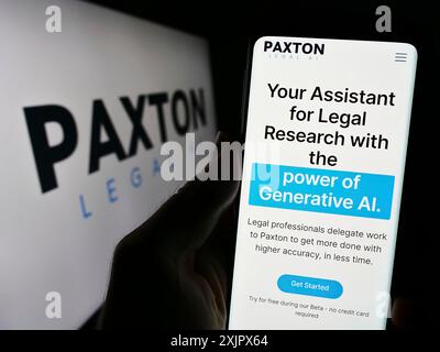 Stoccarda, Germania, 09-27-2023: Persona che detiene il cellulare con il sito web della società di intelligenza artificiale legale statunitense Paxton ai Inc. Con il logo. Concentrati su Foto Stock