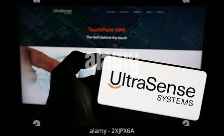 Stoccarda, Germania, 09-28-2023: Persona che tiene il cellulare con il logo della società statunitense UltraSense Systems Inc. Davanti all'azienda Foto Stock