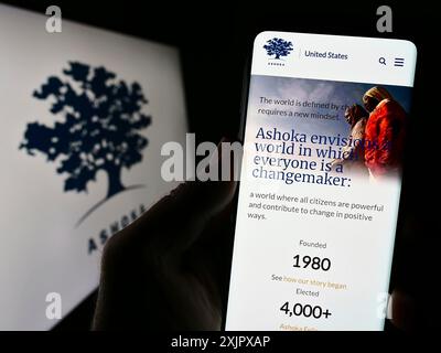 Stoccarda, Germania, 10-09-2023: Persona che detiene un cellulare con pagina web dell’organizzazione imprenditoriale sociale Ashoka davanti al logo. Concentrati su Foto Stock