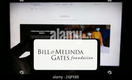 Stuttgart, Germania, 10-06-2023: Persona con smartphone con logo della Fondazione American Bill e Melinda Gates (BMGF) davanti al sito web. Concentrati Foto Stock