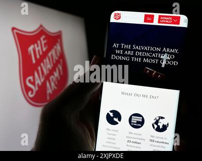 Stoccarda, Germania, 10-09-2023: Persona che tiene in mano lo smartphone con il sito web dell'organizzazione benefica protestante The Salvation Army (TSA) con il logo. Concentrati Foto Stock