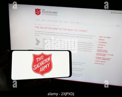 Stoccarda, Germania, 10-09-2023: Persona con smartphone con logo dell'organizzazione benefica protestante The Salvation Army (TSA) di fronte al sito web. Foto Stock