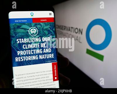 Stoccarda, Germania, 10-11-2023: Persona con smartphone e pagina web dell'organizzazione ambientale Conservation International (ci) con logo. Foto Stock