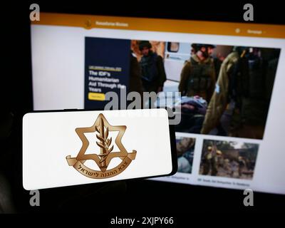 Stoccarda, Germania, 10-27-2023: Persona che tiene il cellulare con il logo delle forze di difesa israeliane (IDF) militari nazionali davanti alla pagina web. Concentrati su Foto Stock