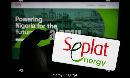 Stoccarda, Germania, 10-30-2023: Persona che tiene il cellulare con il logo della società petrolifera nigeriana Seplat Energy plc di fronte alla pagina web aziendale. Concentrati su Foto Stock