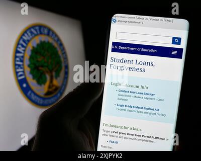 Stoccarda, Germania, 10-30-2023: Persona con smartphone con pagina web del Dipartimento dell'istruzione degli Stati Uniti davanti al sigillo. Concentrati sul centro di Foto Stock