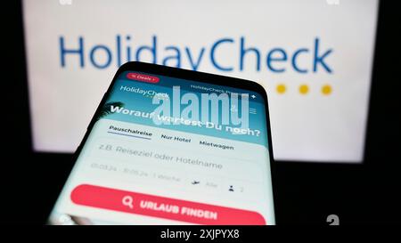 Stoccarda, Germania, 11-02-2023: Telefono cellulare con il sito web della società svizzera HolidayCheck AG, di fronte al logo aziendale. Concentrati su Foto Stock