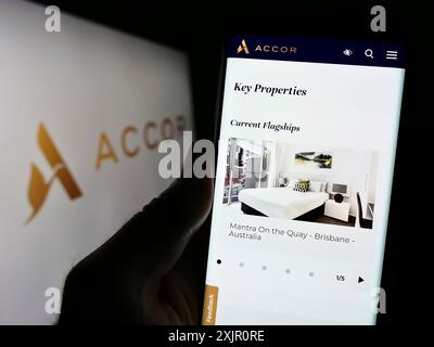 Stoccarda, Germania, 11-10-2023: Persona che detiene il cellulare con pagina web della società di ospitalità francese Accor SA davanti al logo. Concentrati sul centro di Foto Stock
