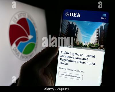 Stoccarda, Germania, 11-11-2023: Persona che detiene un telefono cellulare con sito web della United States Drug Enforcement Administration (DEA) con sigillo. Concentrati su Foto Stock