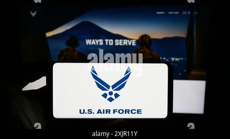 Stoccarda, Germania, 11-12-2023: Persona con smartphone con logo della United States Air Force (USAF) davanti al sito web. Mettere a fuoco il display del telefono Foto Stock