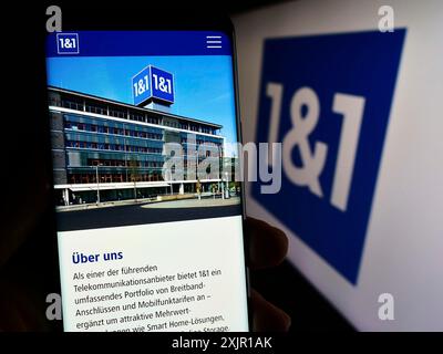 Stoccarda, Germania, 11-15-2023: Persona che detiene uno smartphone con pagina web della società tedesca 1und1 Telecommunication se davanti al logo aziendale. Concentrati Foto Stock