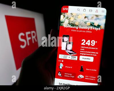 Stoccarda, Germania, 12-07-2023: Persona che detiene lo smartphone con pagina web della società francese Societe Francaise du radiophone (SFR) con logo. Foto Stock