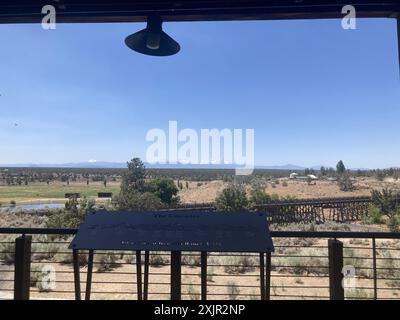 Vista su un ponte di legno in pietra verso le Cascades dal ponte di un ristorante del Brasada Ranch, un resort di lusso vicino a Bend, Oregon. Foto Stock