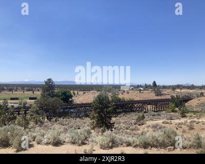 Vista su un ponte di cavalletti al Brasada Ranch, un resort di lusso vicino a Bend, verso le montagne Sisters in Oregon. Foto Stock