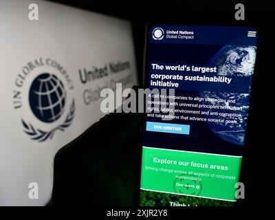 Stoccarda, Germania, 12-09-2023: Persona che tiene il cellulare con pagina web del patto delle Nazioni Unite Global Compact davanti al logo. Concentrati sul centro di Foto Stock