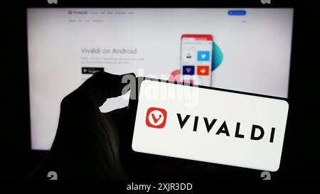 Stoccarda, Germania, 12-18-2023: Persona che detiene un cellulare con il logo della società norvegese di browser web Vivaldi Technologies COME di fronte all'azienda Foto Stock