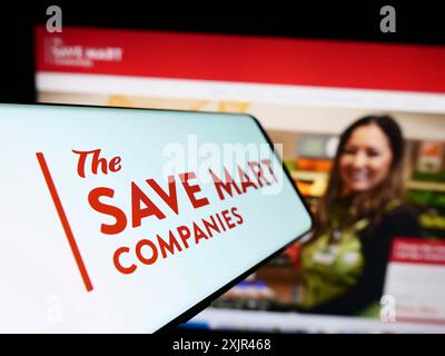 Stuttgart, Germania, 02-03-2024: Smartphone con logo della società americana di supermercati The Save Mart Companies davanti al sito web. Concentrati su Foto Stock