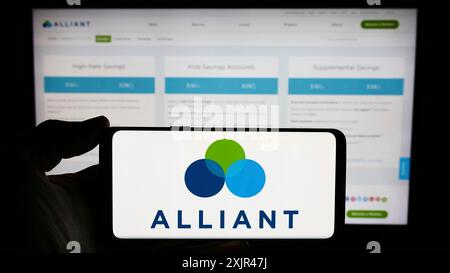 Stoccarda, Germania, 02-03-2024: Persona che detiene il cellulare con il logo dell'istituto finanziario statunitense Alliant Credit Union davanti alla pagina web aziendale. Foto Stock