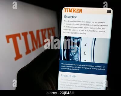 Stoccarda, Germania, 02-08-2024: Persona che detiene il cellulare con il sito web della società americana di produzione di cuscinetti The Timken Company davanti al logo. Concentrati Foto Stock