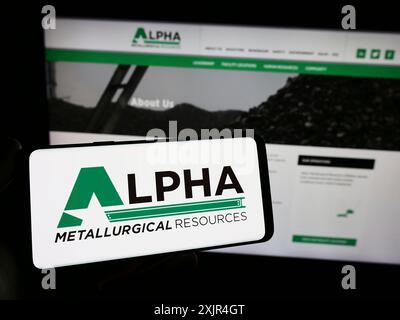 Stoccarda, Germania, 02-08-2024: Persona che detiene lo smartphone con il logo della società mineraria statunitense Alpha Metallurgical Resources Inc. Davanti al sito web. Foto Stock