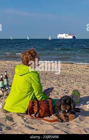 Donna anziana che guarda barche, barche a vela, traghetto, cane, bottiglie di birra, Kieler Woche, Falckensteiner Strand, Kieler Foerde, Kiel, Schleswig-Holstein Foto Stock