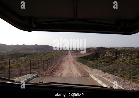 Guarda attraverso il parabrezza di un veicolo da safari su una pista sterrata in fase di sviluppo sull'isola di Sir Bani Yas, un'antica cupola di sale ad Abu Dhabi, Emirati Arabi Uniti. Foto Stock