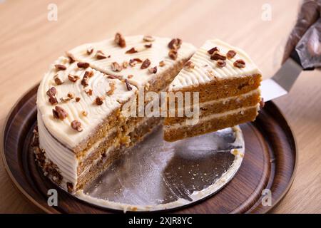 Deliziosa fetta di torta alla carota con glassa al formaggio. Un succulento primo piano di una fetta di torta di carote con ricca glassa di formaggio spalmabile. Foto Stock