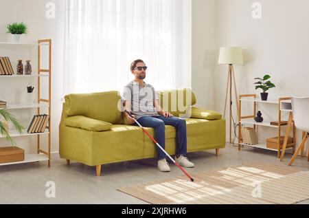 Uomo cieco che riposa sul divano a casa Foto Stock