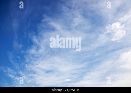 Il cielo è una bella tonalità di blu con soffici nuvole bianche sparse su di esso, creando un tranquillo paesaggio naturale Foto Stock