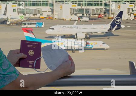 Die Corona-Fälle steigen an. MIT Reisepass und FFP2- Atemschutzmaske am Flughafen München. München Bayern Deutschland *** Corona casi in aumento con passaporto e respiratore FFP2 presso l'aeroporto di Monaco Monaco Baviera Germania Copyright: XRolfxPossx Foto Stock