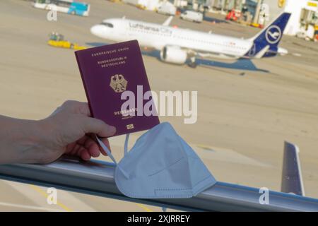Die Corona-Fälle steigen an. MIT Reisepass und FFP2- Atemschutzmaske am Flughafen München. München Bayern Deutschland *** Corona casi in aumento con passaporto e respiratore FFP2 presso l'aeroporto di Monaco Monaco Baviera Germania Copyright: XRolfxPossx Foto Stock