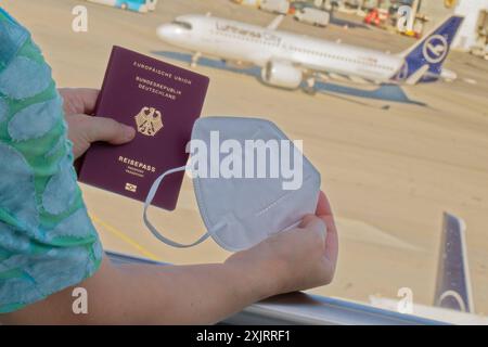 Die Corona-Fälle steigen an. MIT Reisepass und FFP2- Atemschutzmaske am Flughafen München. München Bayern Deutschland *** Corona casi in aumento con passaporto e respiratore FFP2 presso l'aeroporto di Monaco Monaco Baviera Germania Copyright: XRolfxPossx Foto Stock