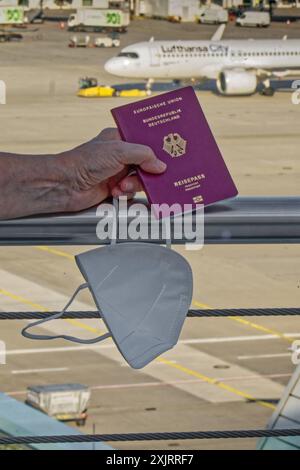 Die Corona-Fälle steigen an. MIT Reisepass und FFP2- Atemschutzmaske am Flughafen München. München Bayern Deutschland *** Corona casi in aumento con passaporto e respiratore FFP2 presso l'aeroporto di Monaco Monaco Baviera Germania Copyright: XRolfxPossx Foto Stock