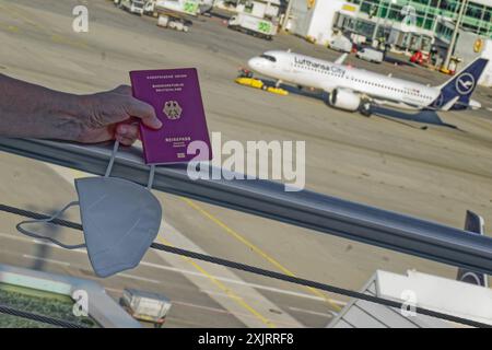 Die Corona-Fälle steigen an. MIT Reisepass und FFP2- Atemschutzmaske am Flughafen München. München Bayern Deutschland *** Corona casi in aumento con passaporto e respiratore FFP2 presso l'aeroporto di Monaco Monaco Baviera Germania Copyright: XRolfxPossx Foto Stock