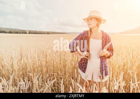 Donna campo di grano. Agronomo, agricoltore donna che controlla i picchi d'orzo maturo dorato nel campo coltivato. Primo piano della mano femminile sulla piantagione in agricoltura Foto Stock