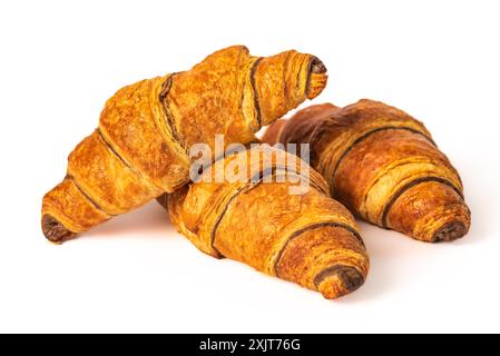 Un trio di croissant perfettamente cotti, marrone dorato e scaglie, sono impilati su uno sfondo bianco. I croissant hanno una leggera lucentezza e strati visibili Foto Stock