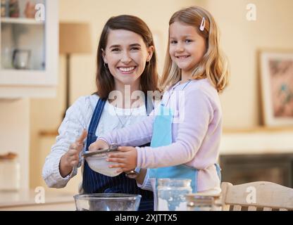 Mamma, ritratto e figlia felici con setaccio da forno in cucina per farina, dessert o mescolare gli ingredienti a casa. Bambino piccolo, ragazzina Foto Stock