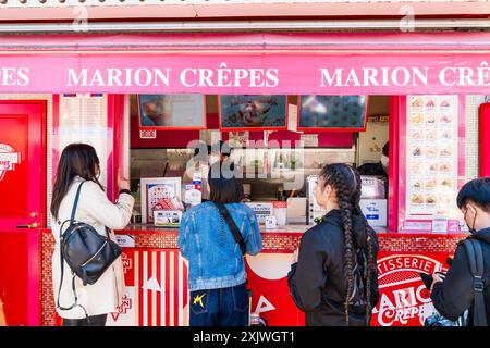 I clienti che aspettano in fila per essere serviti al banco da asporto della filiale Harajuku di Marion Crepes, un lussuoso e popolare pancake dolce. Foto Stock