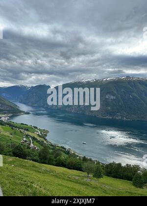 Una vasta distesa d'acqua racchiusa da torreggianti montagne in un giorno coperto Foto Stock