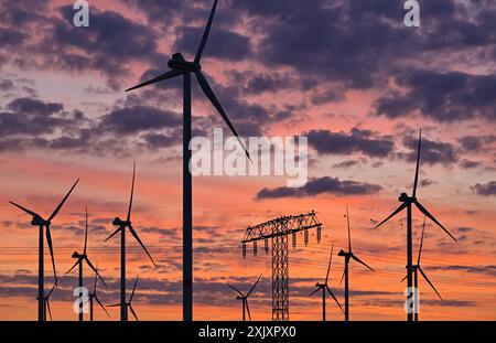 Jacobsdorf, Germania. 20 luglio 2024. Il cielo mattutino risplende luminoso poco prima dell'alba sulle turbine eoliche del parco eolico "Odervorland" nel Brandeburgo orientale. Crediti: Patrick Pleul/dpa/Alamy Live News Foto Stock