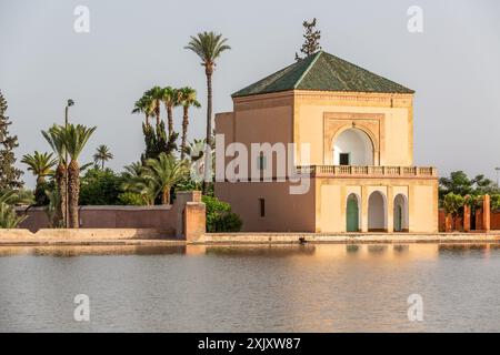 Il padiglione Menara di Marrakech si riflette nel corpo d'acqua che lo circonda, alla luce del tardo pomeriggio Foto Stock