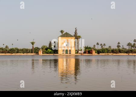 Il padiglione Menara di Marrakech si riflette nel corpo d'acqua che lo circonda, alla luce del tardo pomeriggio Foto Stock