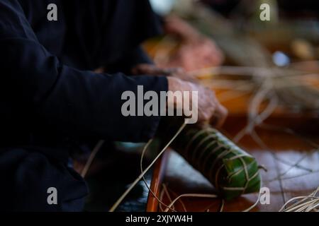 Preparare la torta Tet da una vecchia artigiana. Tradizionale cibo vietnamita per il Capodanno. Messa a fuoco selettiva Foto Stock