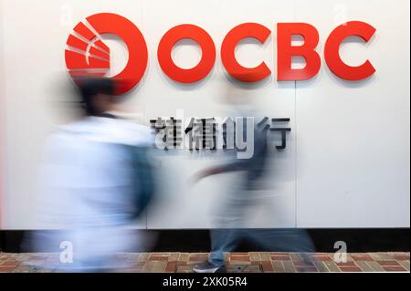 I pedoni passano davanti alla multinazionale di servizi bancari e finanziari di Singapore, Oversea-Chinese Banking Corporation Limited (OCBC), a Hong Kong. Foto Stock