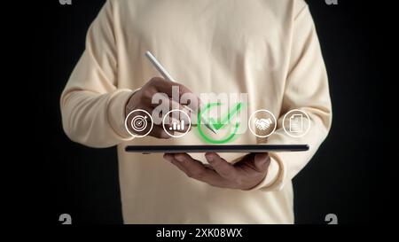 Uomo scrivere o spuntare il segno corretto per approvare documento o progetto, domanda di certificato, gestione e assicurazione della qualità, certificazione aziendale, Foto Stock