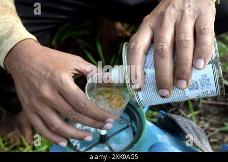un agricoltore che versa erbicidi e sostanze chimiche nel dosatore Foto Stock