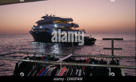 Barca per immersioni subacquee ormeggiata al largo della barriera corallina di Daedalus al tramonto nel Mar Rosso al largo di Hurghada, Egitto. Foto Stock