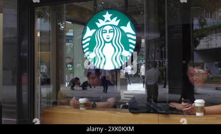 Hong Kong, Cina. 12 luglio 2024. I clienti bevono e guardano il loro smartphone in un coffee store Starbucks a Hong Kong, Cina (foto di Serene Lee/SOPA Images/Sipa USA) credito: SIPA USA/Alamy Live News Foto Stock