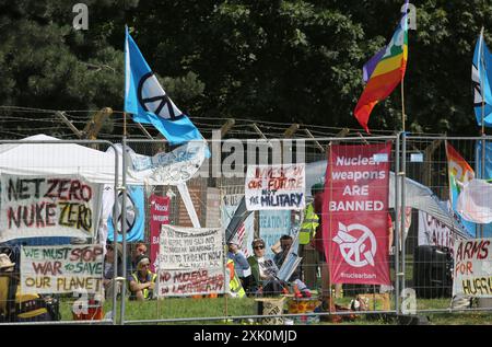 20 luglio 2024, Lakenheath, Inghilterra, Regno Unito: I manifestanti si riuniscono nell'area di protesta designata, dove le recinzioni sono state coperte da striscioni fuori dalla base dell'aeronautica militare di Lakenheath, durante la manifestazione. La protesta è stata organizzata dalla Campaign for Nuclear Disarmament (CND), i cui sostenitori si oppongono al potenziale ritorno di armi nucleari alle basi militari del Regno Unito, come la RAF Lakenheath dopo che è stato riferito che gli Stati Uniti intendono trasferire bombe nucleari alla base. Dopo una lunga protesta le armi nucleari furono rimosse da Lakenheath nel 2008. (Immagine di credito: © Martin Pope/ZUMA Press Wire) ed Foto Stock