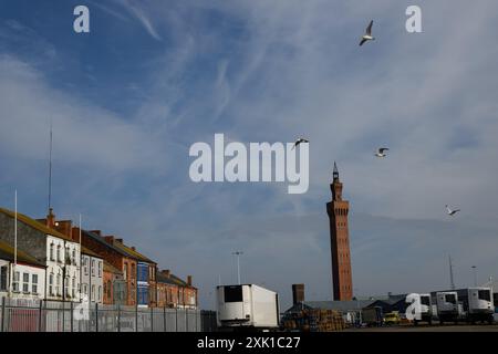 L'iconica Grimsby Dock Tower, vista dietro gli edifici a bordo e con le tapparelle. Situata nel nord-est del Lincolnshire, questa città storica aveva una fiorente industria della pesca, ma con l'industria della pesca in gran parte scomparsa, la zona ora soffre di privazione e abbandono. Mentre il Regno Unito si candida alle elezioni generali, il voto in queste roccaforti del "muro rosso” sarà un fattore critico per il risultato elettorale. ©Justin Griffiths-Williams 00442085339882 00447850053473 Foto Stock